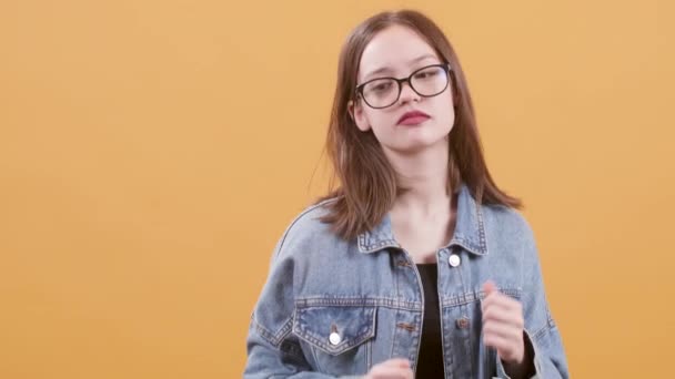 Εφηβικό κορίτσι στα γυαλιά χορεύει σεμνά, ακούγοντας μουσική — Αρχείο Βίντεο