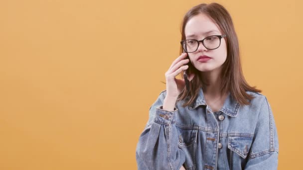 Menina adolescente bonita parece inseguro e estressado ao falar em seu telefone — Vídeo de Stock