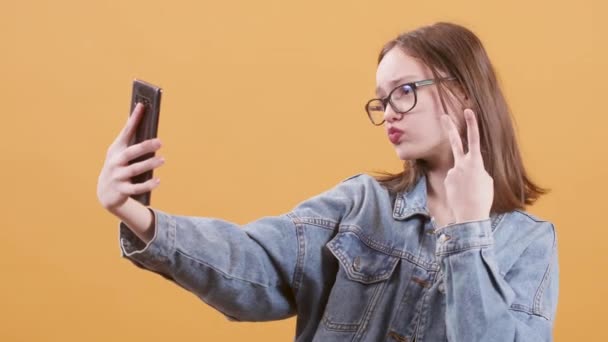 Hermosa adolescente haciendo un montón de selfies en su teléfono inteligente — Vídeos de Stock