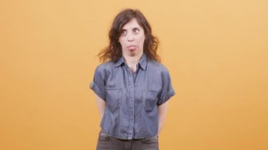 Kameraya komik yüzler gösteren sarı arka plan üzerinde Pretty kadın