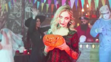 Bir cadılar bayramı partisinde elinde bir jack-o-fener ile seksi vampirler
