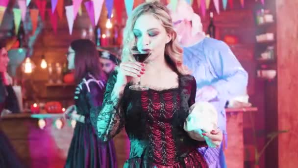 Vampiress soddisfa il suo gusto di sangue a una festa di Halloween con un teschio nelle mani — Video Stock