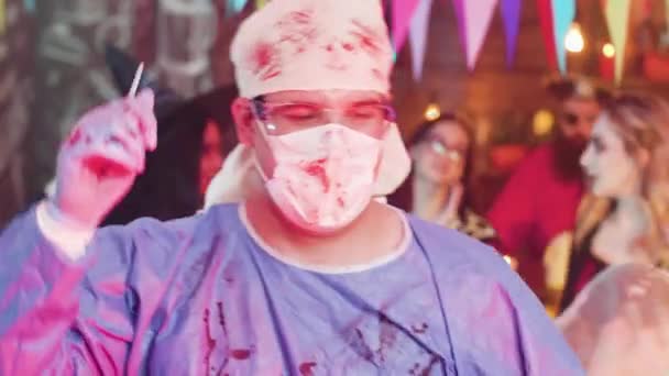 Uomo adulto ad una festa di Halloween che balla in costume da chirurgo pazzo — Video Stock