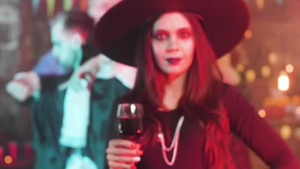 Femme en costume de sorcière avec un beau sourire et les yeux mauvais à une fête d'Halloween — Video