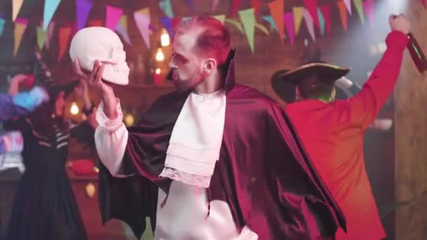Hombre disfrazado de vampiro baila con un cráneo en la mano — Vídeo de stock