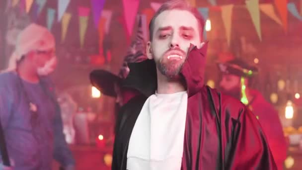 Ung man förklädd till ghoul eller vampyr gör roliga dansrörelser på en halloweenfest — Stockvideo
