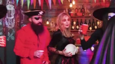 Yerel bir barda bir cadılar bayramı partisinde kötü karakter gibi giyinmiş eğlenceli olan arkadaş Grubu