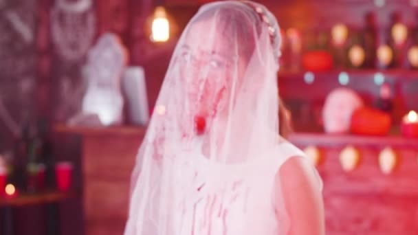 Portré egy fiatal lány, egy véres menyasszony fátylat az arcán, mint a Halloween jelmez — Stock videók