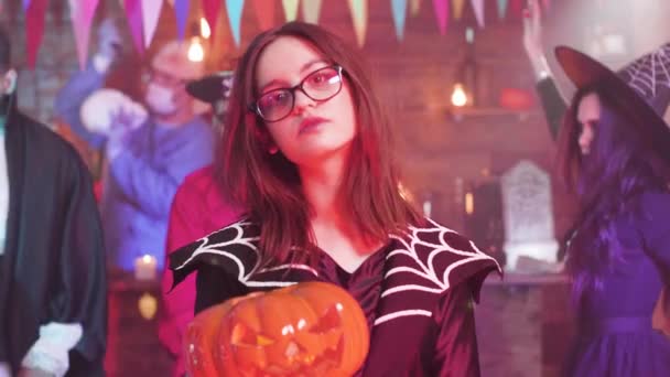 Teen girl in evil witch costume with a jack-o-lantern in her hands — Stock Video