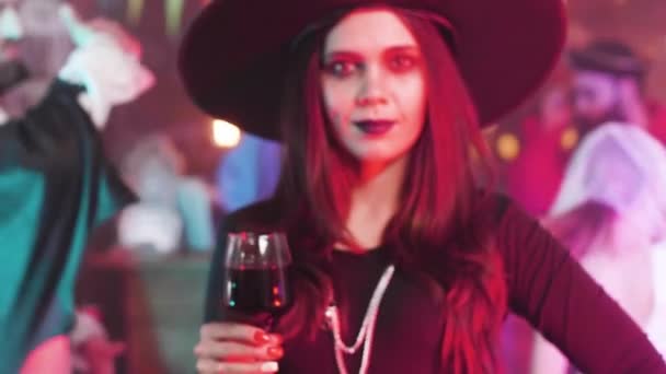 Vonzó nő egy gyönyörű mosoly álcázott boszorkány egy Halloween Party — Stock videók
