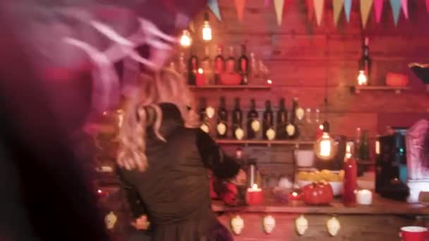 Ведьмы, вампиры и другие злые персонажи на Хэллоуинской вечеринке пьют и веселятся — стоковое видео