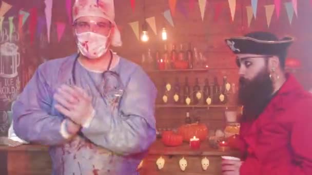 Groep jonge mensen dansen en drinken op een Halloween feest — Stockvideo