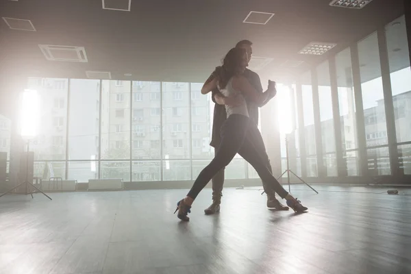 Dançarinos kizomba mostrando sua paixão por dançar kizomba na frente de uma sala de dança com grandes janelas no fundo — Fotografia de Stock