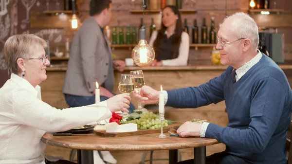 Старший мужчина в очках со своей женой на свидании в ресторане — стоковое фото