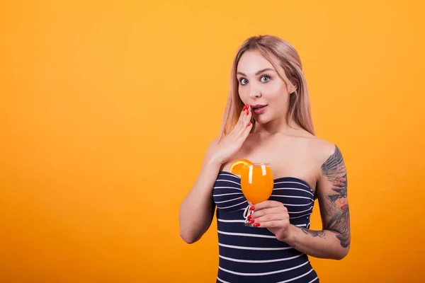 Retrato de chica bonita en traje de baño sexy sosteniendo un cóctel fresco sobre fondo amarillo —  Fotos de Stock