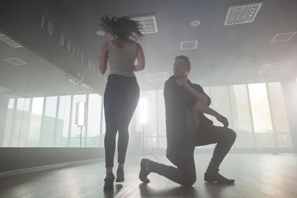 男性舞者旋转他的伙伴，看着她在练习舞蹈室 — 图库照片