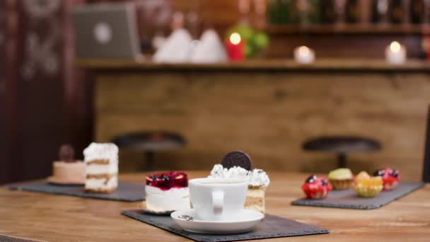 Taza fresca de café junto a pasteles dulces y pasteles — Vídeo de stock