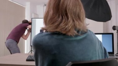 Fotoğrafçının çektiği fotoğraflara bakan müşteri