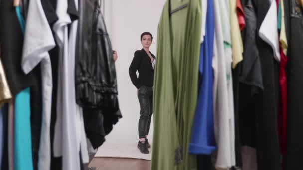 Tir à travers un rack de vêtements prêts pour la séance photo — Video