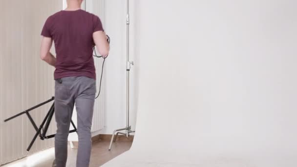 Photographe de mode installant des lampes flash dans le studio — Video