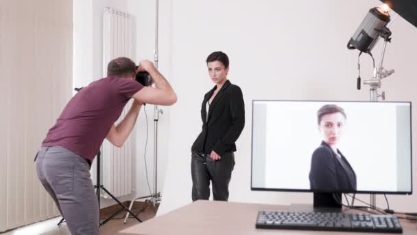 Modelo está posando para el fotógrafo y las imágenes se muestran en la pantalla de la computadora — Vídeos de Stock