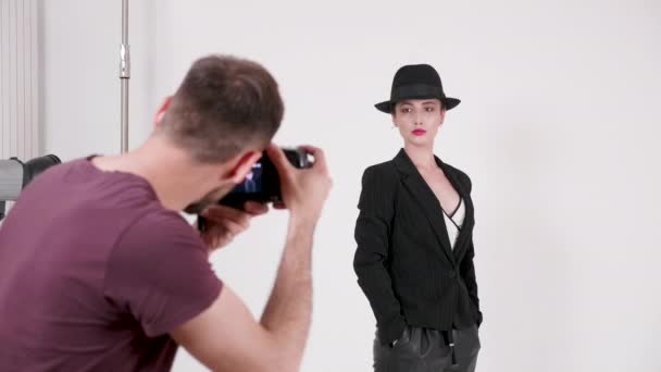 Handhållen bild av fotografen visar modell hur man poserar — Stockvideo