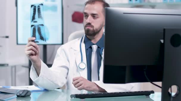 医師は肺を持つX線を注意深く調べる — ストック動画