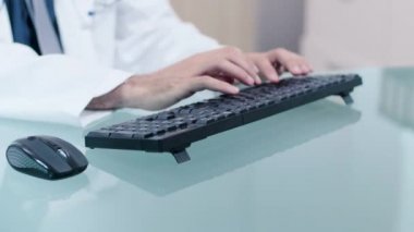 Klavyede yazan bilgisayar üzerinde çalışan doktor