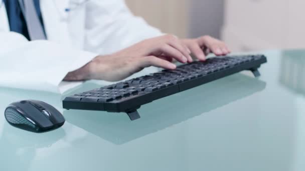 Arzt tippt am Computer auf der Tastatur — Stockvideo