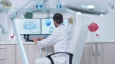 Doktor modern ofis veya araştırma merkezinde 3d beyin taramaları ile bir bilgisayar üzerinde çalışıyor