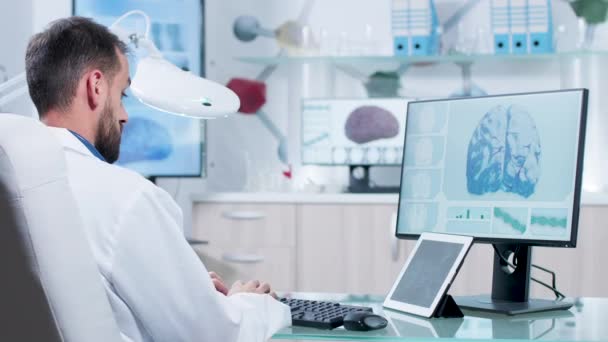 En las instalaciones de investigación moderna, el médico está mirando los escáneres de rayos X — Vídeos de Stock