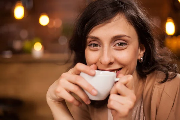 Joven mujer atractiva sonriendo a la cámara en la cafetería —  Fotos de Stock