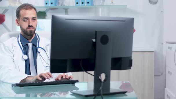 Dolly strzał z lekarzem pracy w swoim nowoczesnym biurze — Wideo stockowe