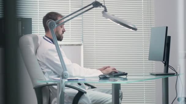 Doutor trabalhando em seu escritório no computador — Vídeo de Stock