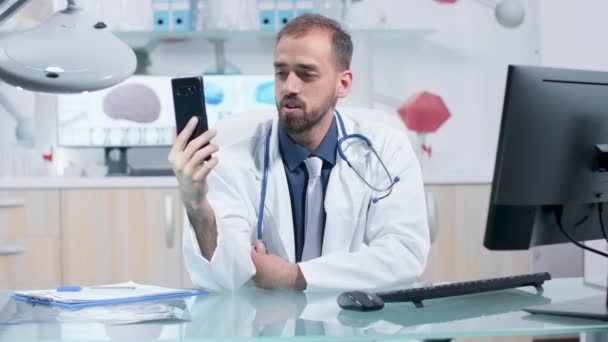 Läkare som har ett videosamtal på sin telefon i moderna och ljusa forskningscentrum — Stockvideo