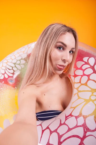 Ritratto di ragazza divertente in costume da bagno prendere un selfie e attaccare la lingua alla fotocamera — Foto Stock