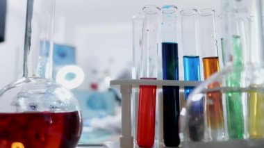 Laboratuvarda bir araştırmacı yaklaşan çeşitli renkli sıvı ile tüplerPov atış