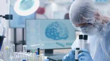 Modern laboratuvarbiliminde tulumbilimi mikroskoptan bakıyor.