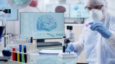 Bir kan örneğine bakan koruyucu tulum profesyonel araştırmacı