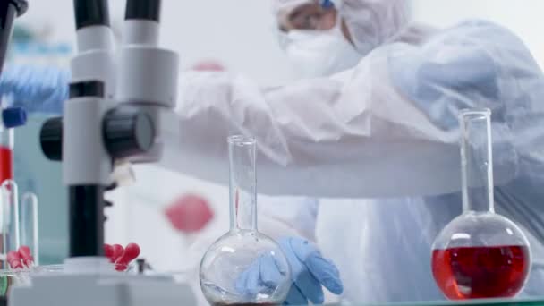 Портативний знімок вченого, який бере червоні зразки з трубки — стокове відео