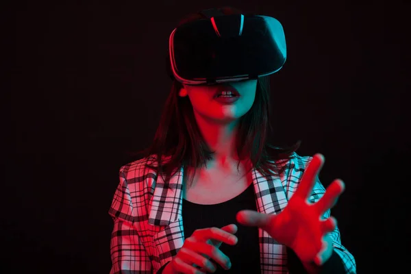 Retrato de chica asombrada abriendo la boca con emoción y extendiendo los brazos mientras interactúa con algo con gafas de realidad virtual — Foto de Stock