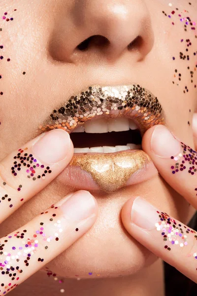 Donna con labbra dorate e brillantini sulle mani in studio — Foto Stock