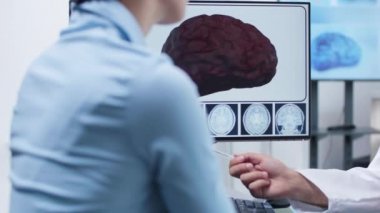 3d beyin simülasyonu gösteren doktor ellerinin yakın çekim görüntüleri