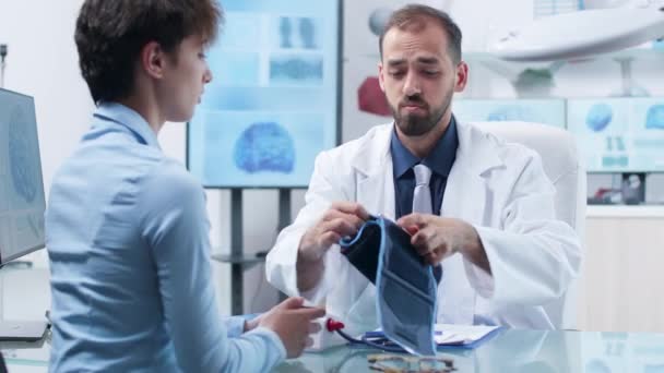 Onderzoeker bloeddruk meten aan een jonge vrouwelijke kandidaat — Stockvideo