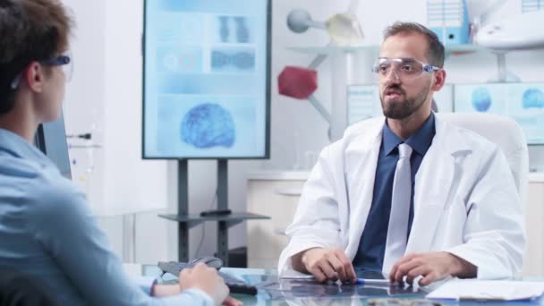 Médico con gafas de realidad aumentada mostrando algo a un paciente — Vídeos de Stock