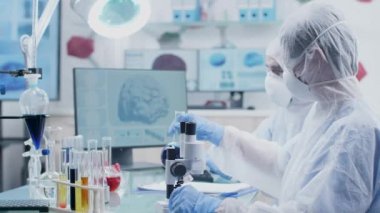 Yüksek son modern araştırma tesisinde iki kimyager renkli sıvı örnekleri ile çalışıyor