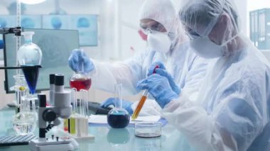 Tüplerden örnek sıvı ile çalışan iki bilim adamı dolly atış