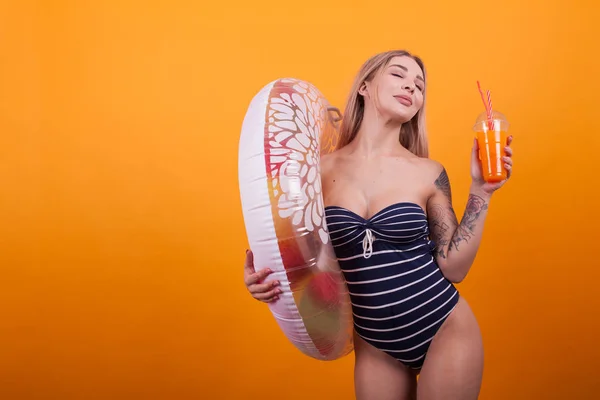 Schöne sexy junge Frau im Luxus-Badeanzug mit Schwimmring denkt über ihren nächsten Sommerurlaub nach — Stockfoto