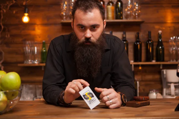 Skäggiga hipster bartender spela med hans trick-kort. — Stockfoto