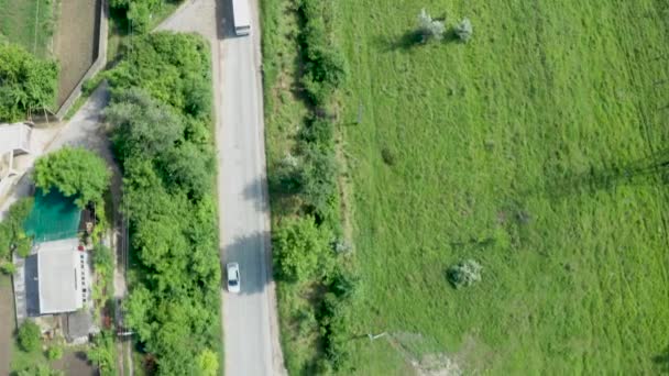 Вид зверху вниз по повітрю після автобуса на дорозі в сільській місцевості — стокове відео